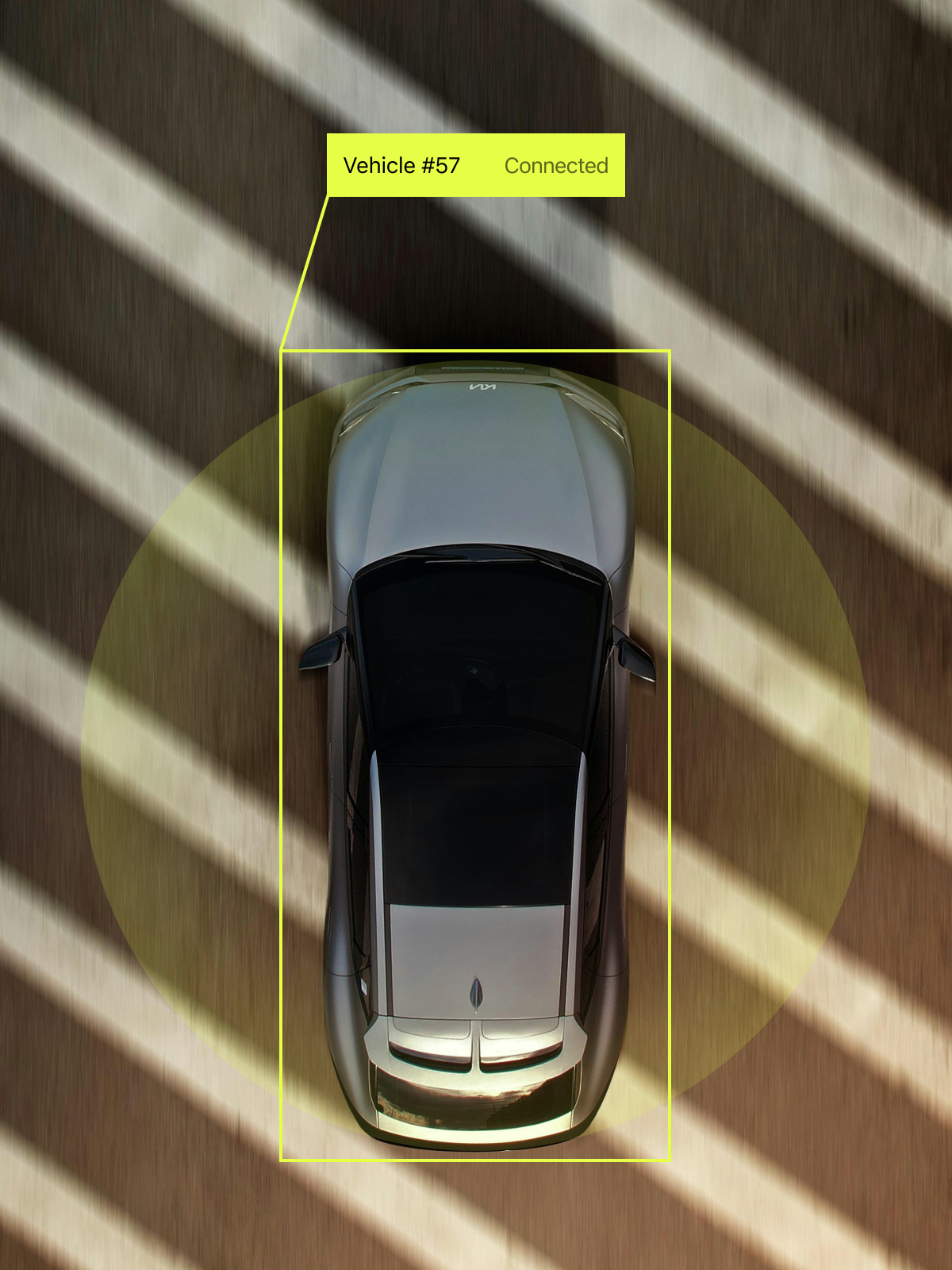 An overhead view of a grey sedan labeled "Vehicle #57" with a "Connected" tag, surrounded by diagonal shadows on a green background.